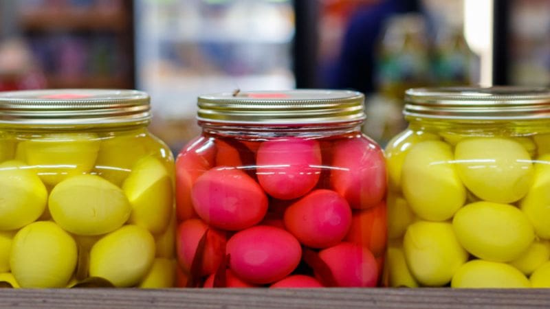 Three jars containing pickled eggs that can be used in recipes with pickled eggs.