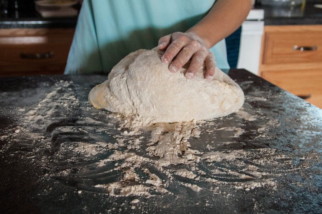 Person kneading homemade dough for making buttery biscuits with raw Jersey cow milk. 