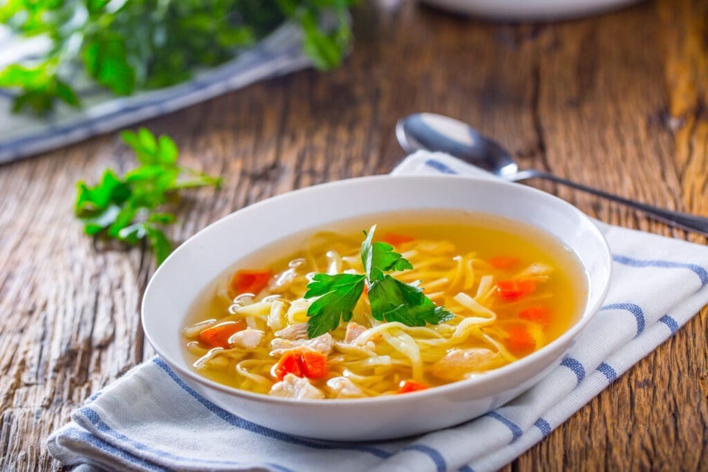 a bowl of chicken noodle soup with chicken bone broth as the base. 